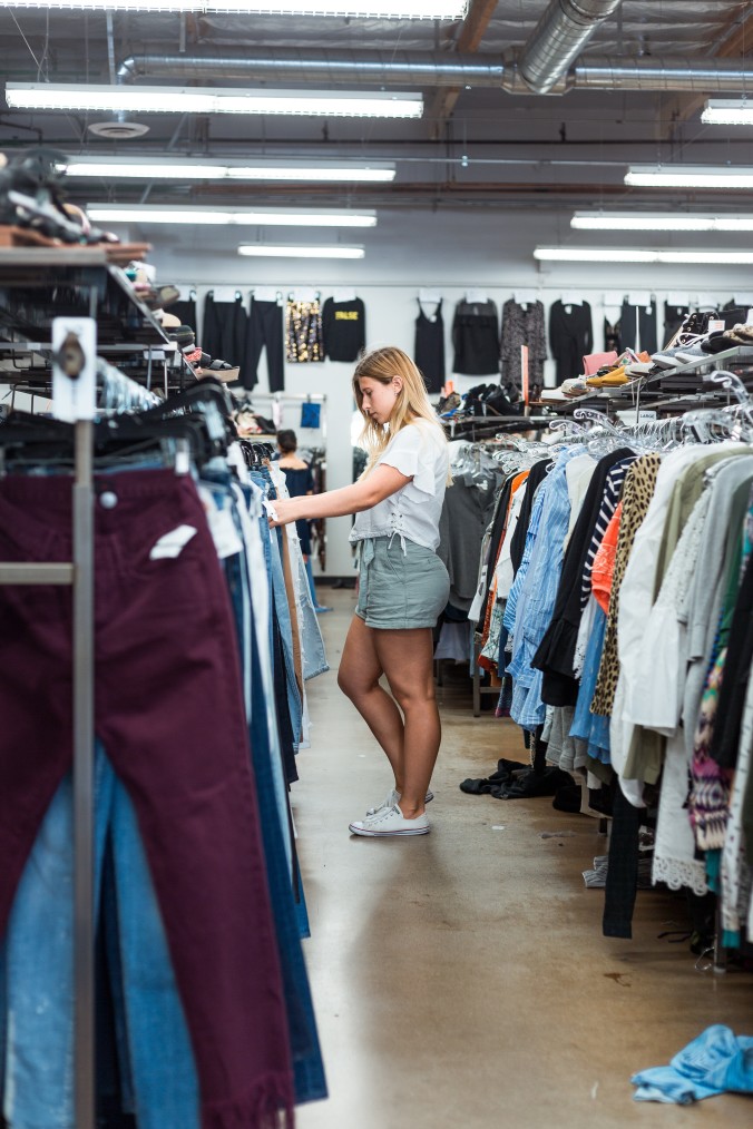 young women shopping for pants at a thrift store